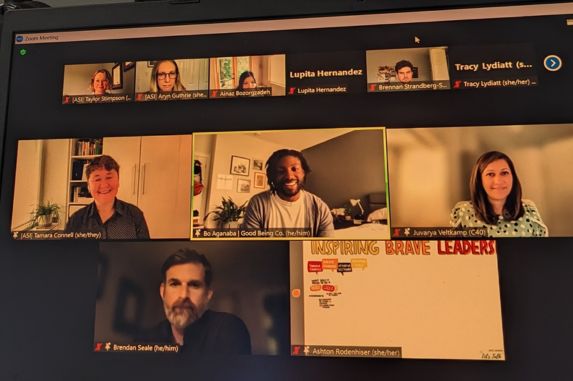 A screenshot of a Zoom meeting with seven participants, each in separate video boxes, some smiling. One screen shows a presentation slide with the words "INSPIRING BRAVE LEADERS" in orange and red text.