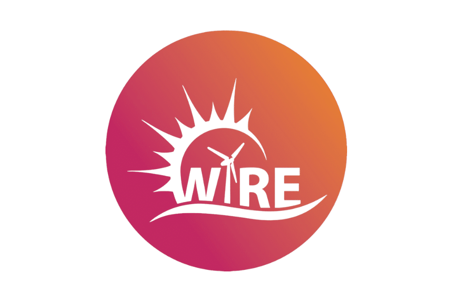 A circular logo with a gradient background transitioning from orange to pink. The design includes a stylized sun with rays, a wind turbine, and the word "WIRE" in green capital letters integrated into the image, celebrating women's empowerment in sustainable energy.